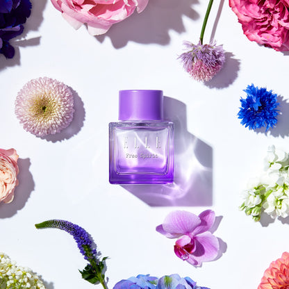 Lifestyle image of ELLE Free Spirit by ELLE Parfums, featuring a striking purple bottle with a feminine and captivating carton design. This fragrance embodies the celebration of individuality, the vibrancy of a free spirit, and the strength of womanhood. The eau de parfum offers a unique blend of woody and tropical notes, making it a bold and empowering choice.