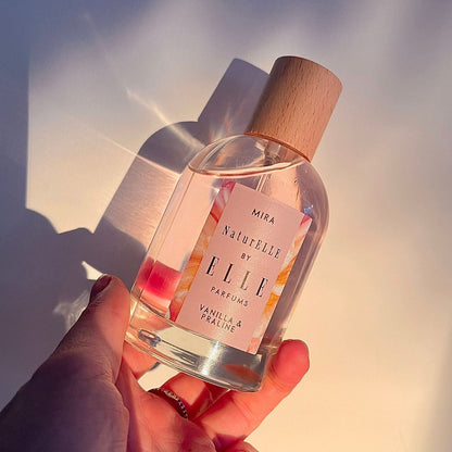 Lifestyle image of Mira by ELLE Parfums 100ml. The main ingredients in Mira Eau De Parfum are Vanilla & Praline. It's vegan, cruelty-free, naturally and ethically sourced. It's perfect for day and night.