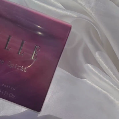 UGC video of a girl spritzing ELLE Free Spirit by ELLE Parfums, featuring a striking purple bottle with a feminine and captivating carton design. This fragrance embodies the celebration of individuality, the vibrancy of a free spirit, and the strength of womanhood. The eau de parfum offers a unique blend of woody and tropical notes, making it a bold and empowering choice.
